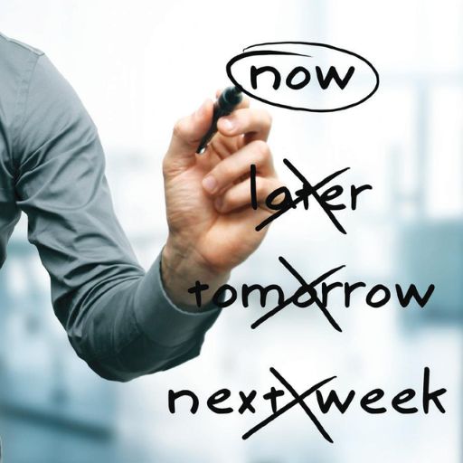 A person in a gray shirt writes “now” in a circle on glass, above crossed-out words: “later,” “tomorrow,” and “next week.” The image conveys a message about overcoming procrastination and taking immediate action.