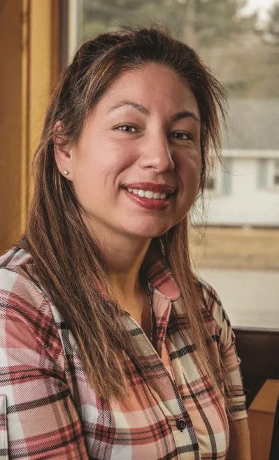 Portrait of Melody Rose Paul, smiling, photographed indoors near a window.