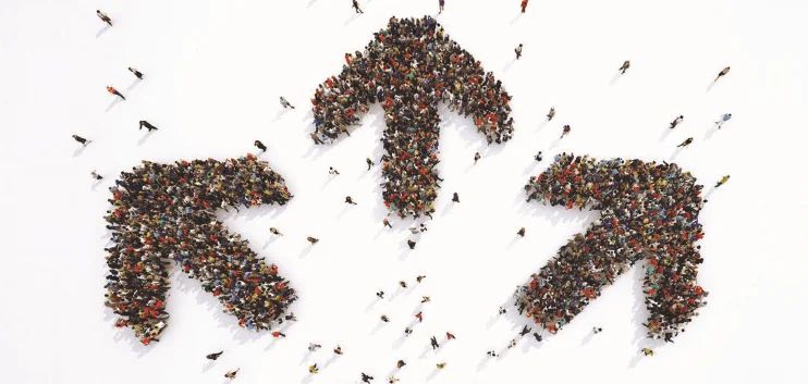 Crowds of people massed into three large arrows pointing in different directions.